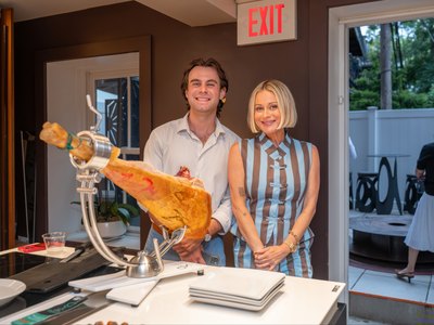 Two guests behind a whole ham on its carving stand